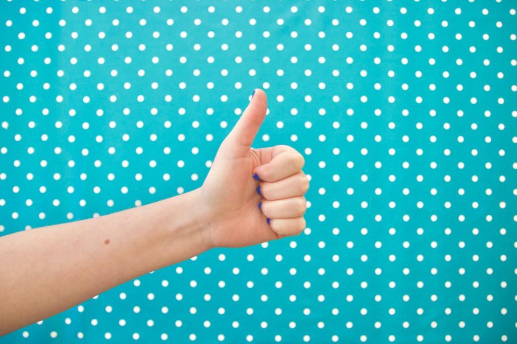 Thumbs up on bright polkadot background